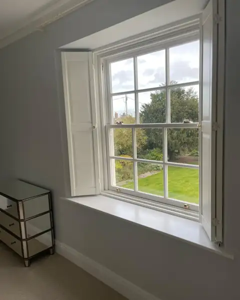 Painted hardwood shutters on a Georgian sash window